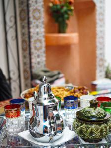 a table with a tea kettle and plates of food at Dar Sarah-Marrakech, riad authentique idéalement situé. in Marrakesh