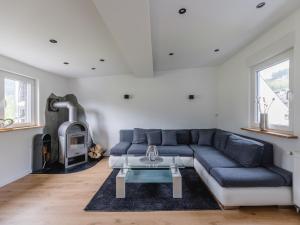 ein Wohnzimmer mit einem blauen Sofa und einem Kamin in der Unterkunft Ferienwohnung Kurparkblick Sauerland in Lennestadt