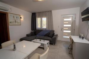 ein Wohnzimmer mit einem Sofa und einem Tisch in der Unterkunft Olive & Almond Apartment in Bol