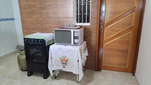 a microwave sitting on top of a table next to a door at Hospedagem da Almira - Apartamento 2 in Manaus