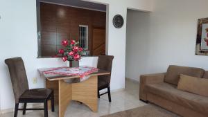 una sala de estar con una mesa con un jarrón de flores. en Hospedagem da Almira - Apartamento 2, en Manaus