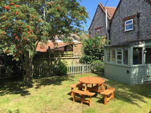 a picnic table in a yard next to a house at Corner Cottage - base for exploring North Norfolk in Bodham