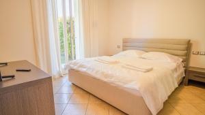 sypialnia z łóżkiem z białą pościelą i oknem w obiekcie Endless Summer Sirmione - Italian Homing w Sirmione +23 zdjęcia