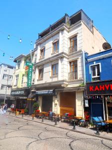 ein Gebäude in einer Stadtstraße mit Tischen und Stühlen in der Unterkunft RENOVA TURiZM HOTEL in Istanbul