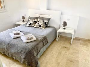 een slaapkamer met een bed en 2 bijzettafels bij New apartment with sea view and pool in Torrevieja