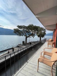 a balcony with chairs and a view of the water at Brissago Lake Apartment in Brissago