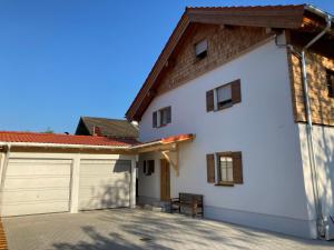 a white house with a garage at Ferienhaus Surheim in Saaldorf-Surheim