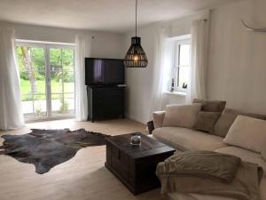 a living room with a couch and a tv at Ferienhaus Surheim in Saaldorf-Surheim