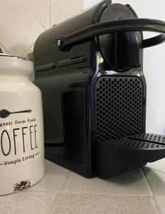 eine Kaffeemaschine auf einer Theke neben einem Behälter in der Unterkunft Mondello Holiday Home in Mondello