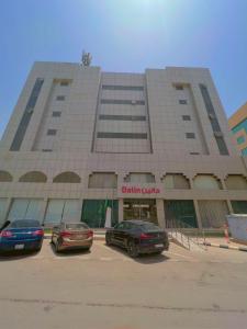 Dalin Hotel في الرياض: سيارتين متوقفتين في موقف للسيارات امام مبنى