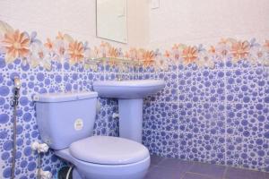 bagno con servizi igienici blu e lavandino di Pleasant Park Holiday Inn a Trincomalee