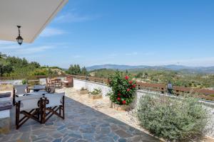 un patio con mesas, sillas y flores en Pure Nature Cottage en Láerma