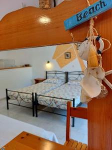 a bedroom with two beds and a hanging sign at Villa Eleni (Studio 1) Fully equiped, near the sea in Agios Gordios