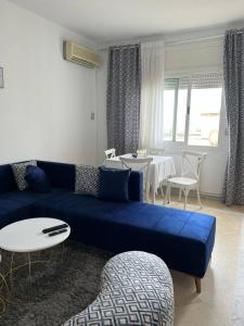 ein Wohnzimmer mit einem blauen Sofa und einem Tisch in der Unterkunft اقامة مريم in Ariana