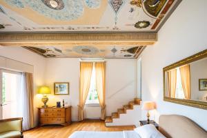 Villa Sassa Hotel, Residence & Spa - Ticino Hotels Group في لوغانو: غرفة نوم بسرير وسقف مع درج
