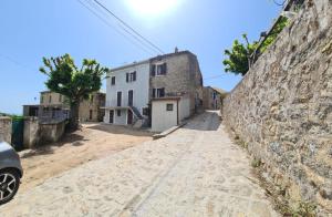 a street in a village with a stone wall at Maison de Vacances Renno in Renno