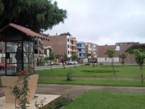 un parque con edificios y un campo de césped en Acojedor, en Lima