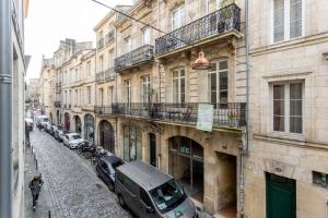 una strada con auto parcheggiate sul lato di un edificio di Bordeaux Bouquiere a Bordeaux