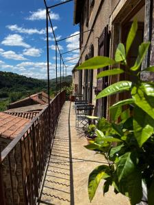 einen Balkon mit Stühlen an der Seite eines Gebäudes in der Unterkunft Les Roches in Comprégnac