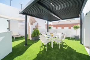 a patio with a table and chairs on grass at BOUTIQUE APARTMENTS- LA GLORIA 1908 in Almería