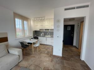 eine Küche und ein Wohnzimmer mit einem Sofa und einem Tisch in der Unterkunft Bárdo Apartman in Balatonlelle