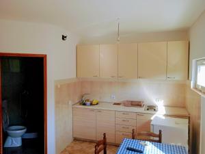 a kitchen with white cabinets and a table and a sink at Apartmani Vukovic in Tivat