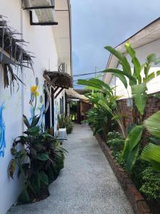 a corridor of a building with plants on the side at Rembulan Langkawi Guesthouse in Pantai Cenang
