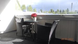 einen Balkon mit einem Tisch und Stühlen sowie einem Fenster in der Unterkunft Gasthouse Oulu in Oulu