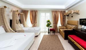 a hotel room with two beds and a couch at Cosmos Hotel Istanbul in Istanbul