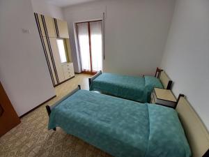duas camas num quarto de hotel com lençóis verdes em Appartamento fronte mare costa dei trabocchi em Vasto