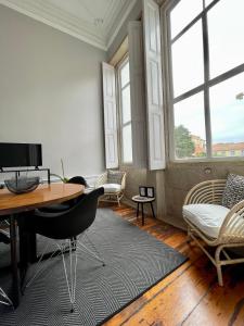 a room with a desk and chairs and windows at AD Apartment - Solar da Avenida in Porto