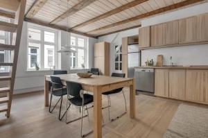 a kitchen with a wooden table and some chairs at Cosy City Apartment Perfect For A Family Or Group! in Copenhagen