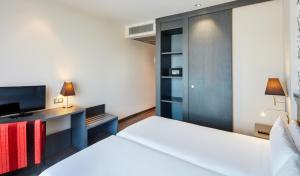 a bedroom with two beds and a tv at Sercotel Plaza Feria in Zaragoza