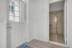 ein Bad mit einer weißen Tür und einer Dusche in der Unterkunft Cosy City Apartment Perfect For A Family Or Group! in Kopenhagen