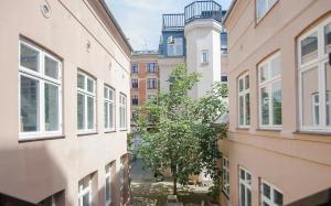 eine Gasse zwischen zwei Gebäuden mit einem Baum in der Mitte in der Unterkunft Cosy City Apartment Perfect For A Family Or Group! in Kopenhagen