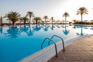 a swimming pool at a resort with palm trees at AQI Hydros Club in Kemer