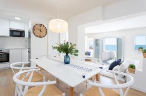 a white dining room with a white table and chairs at Higueron Rental Playa Mira in Benalmádena