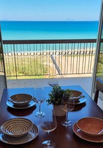 una mesa con copas de vino y vistas a la playa en Miramare Apartment, en Acquedolci