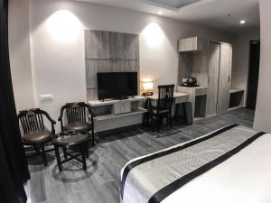 1 dormitorio con 1 cama, escritorio y TV en Peaks And Pines Resort, en Lansdowne