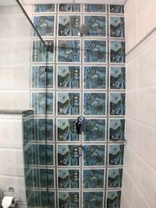 y baño con ducha y pared de azulejos. en Peaks And Pines Resort, en Lansdowne