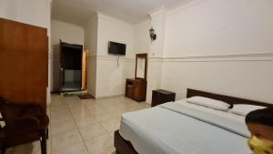 a bedroom with a bed and a tv in a room at Acirasa Homestay Medan in Medan