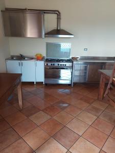 a kitchen with a stove and a tiled floor at Le Tre Dimore - Rifugio Aceroni in San Biagio Saracinesco