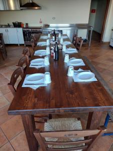 a long wooden table with plates and napkins on it at Le Tre Dimore - Rifugio Aceroni in San Biagio Saracinesco