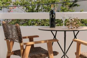 - une table avec une bouteille de vin et une chaise dans l'établissement TERRA FOS NAXOS STUDIOS, à Naxos Chora