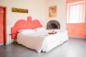 a bedroom with a large bed with a red headboard at Villa Paggi Country House in Carasco