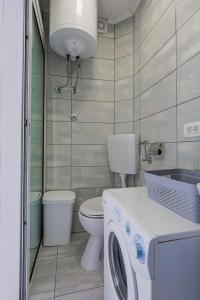 a bathroom with a toilet and a washing machine at Apartman Marica in Split