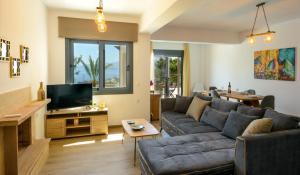 een woonkamer met een bank en een tv bij Elounda Blue Waves in Elounda