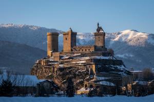 a castle on top of a mountain in the snow at Agréable maison au centre historique de Foix avec garage in Foix
