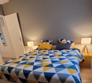 - une chambre avec une couette bleue et jaune sur un lit dans l'établissement APPARTEMENT CHIC EN HYPER CENTRE DE VANNES, à Vannes