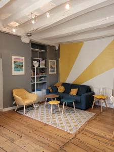 uma sala de estar com um sofá azul e mesas em APPARTEMENT CHIC EN HYPER CENTRE DE VANNES em Vannes